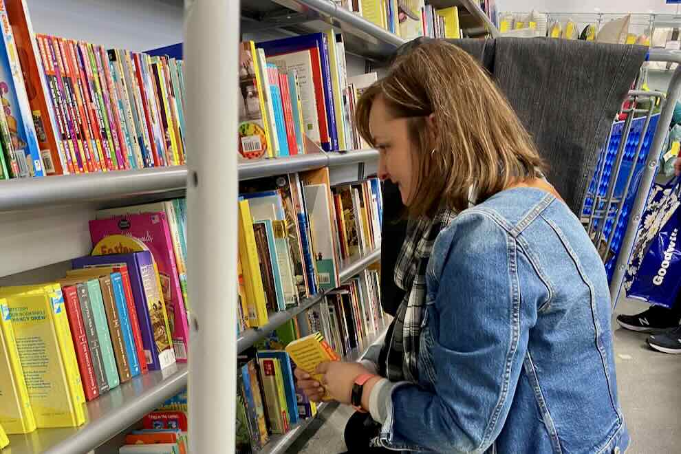 woman shopping for books at Goodwill