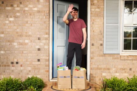 Man on porch accepting Food Lion delivery