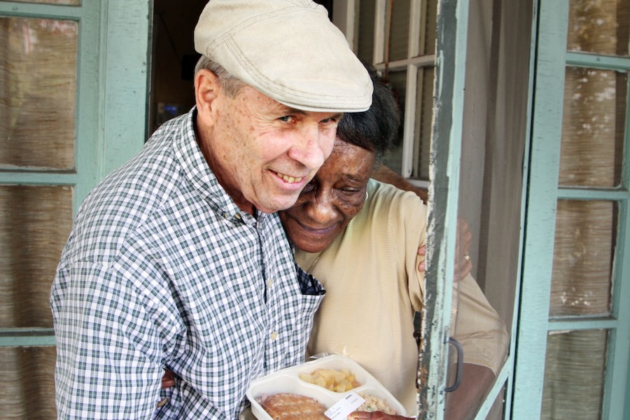 A FeedMore volunteer delivers a meal to a local senior as part of the Meals on Wheels program.