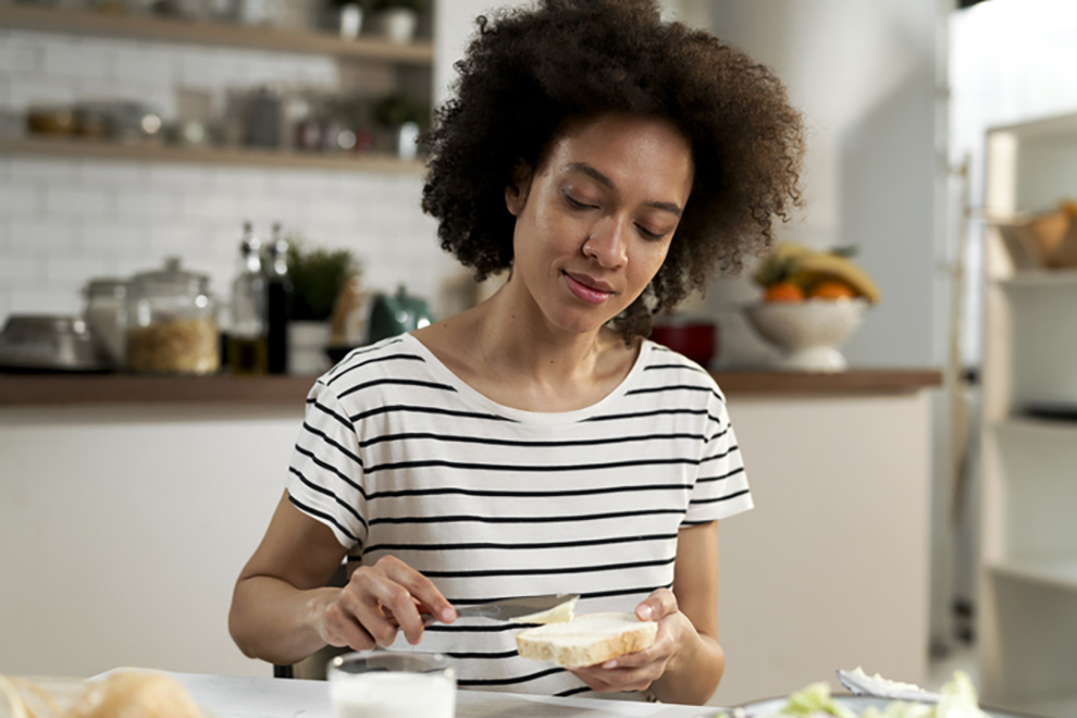 Beautiful young woman making a sandwich