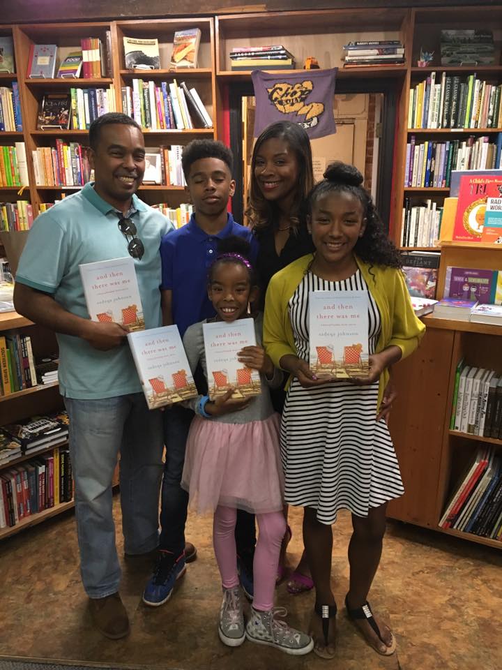 Author Sadeqa Johnson with her husband and young family in a bookstore with her book And Then There Was Me