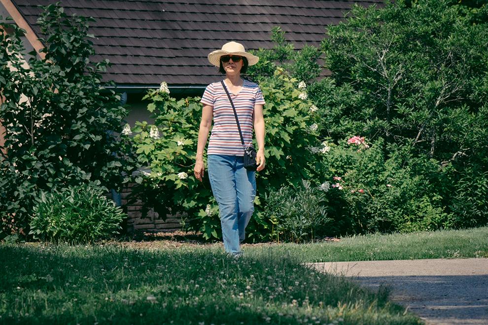 Spring Into Action woman in hat walking in yard outside