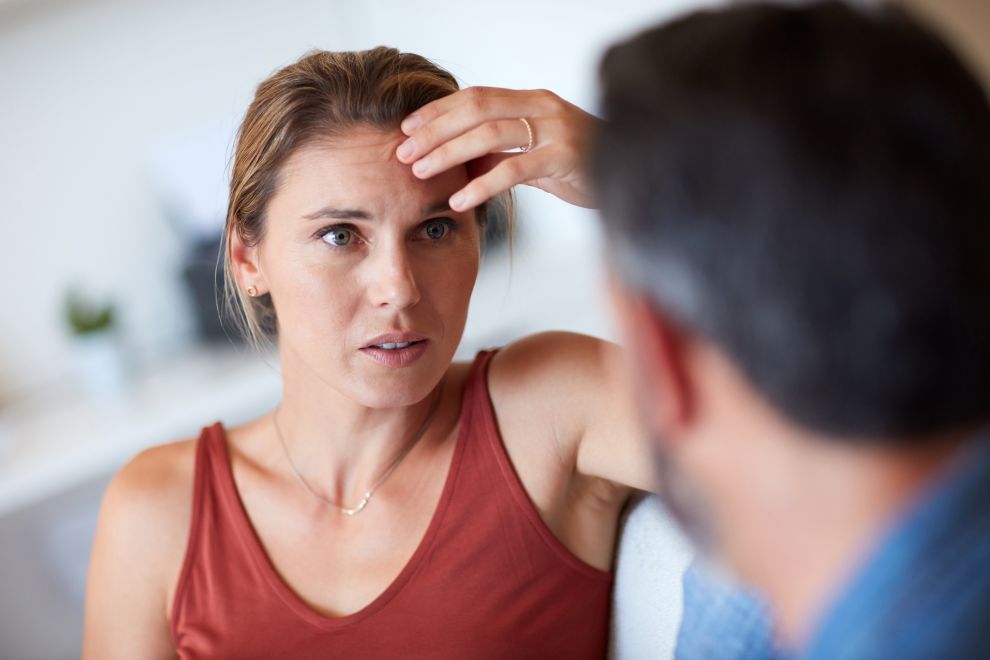 A middle aged woman experiences perimenopause brain fog in conversation with husband