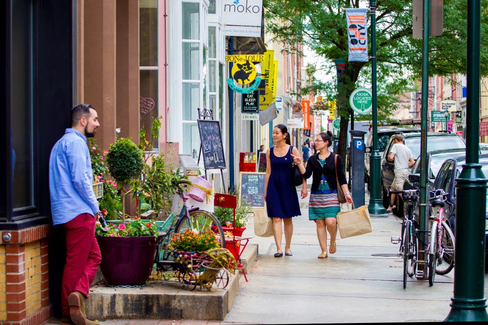 two women holding shopping bags and walking down the street in Philadelphia