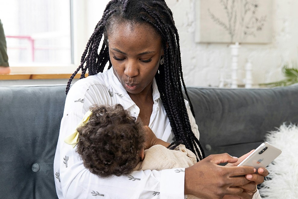 Mother cradling child and holding iPhone