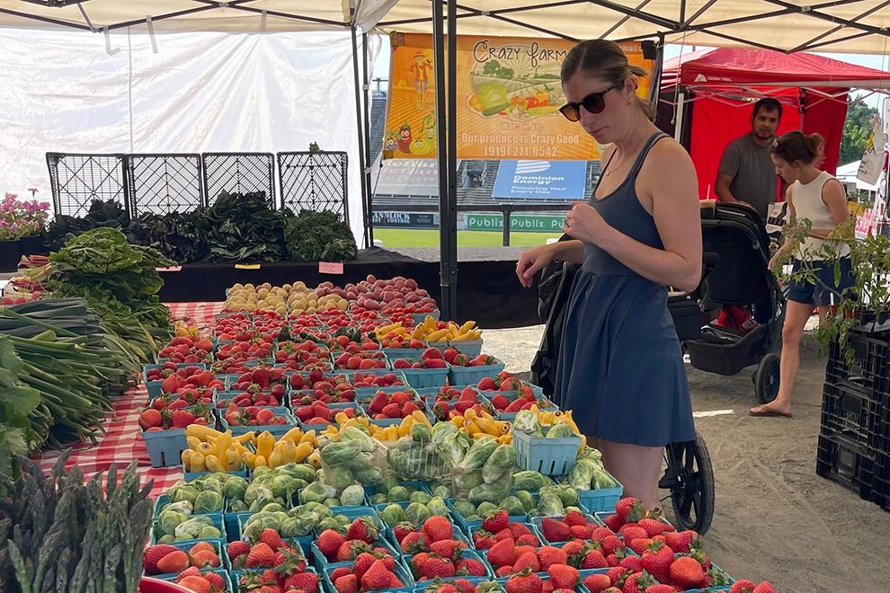 woman looking at produce at the Carytown Farmers Market in Richmond VA