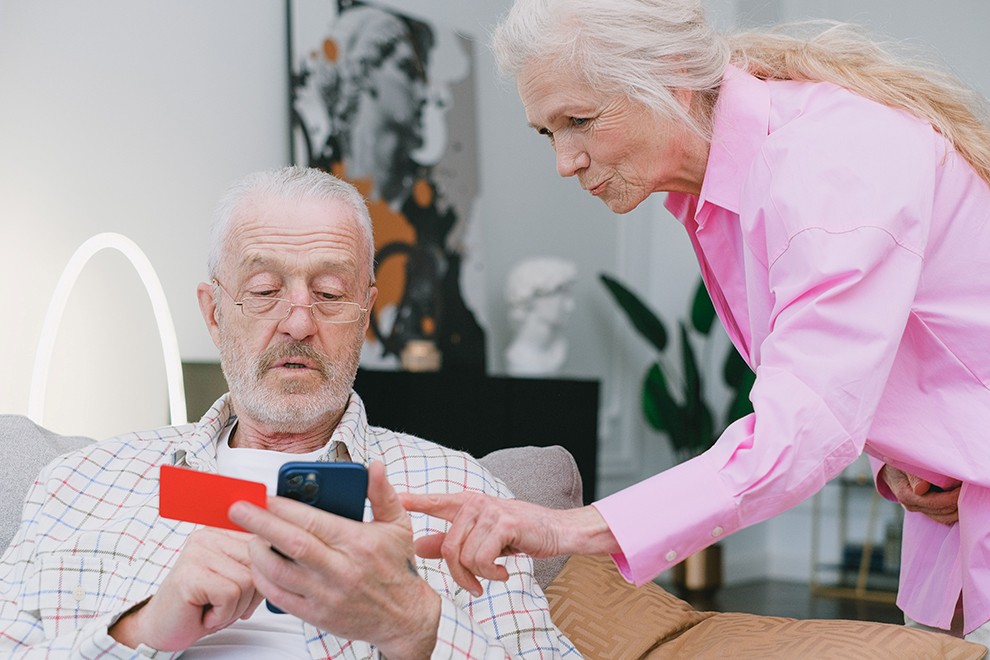 Scam Season older couple looking on an iPhone