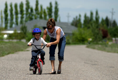 Mom teaching child to ride a bike