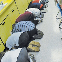 Students demonstrate proper technique during a statewide tornado drill.