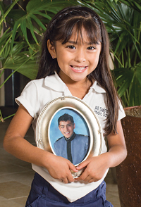 Abril holds a photo of her oldest brother, Julio Cesar, who wasn’t available for the family picture on the previous page.